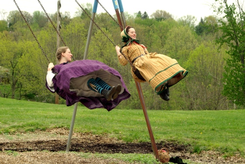 two women in antebellum dress on the swings