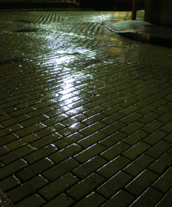 photo of a wet brick street at night