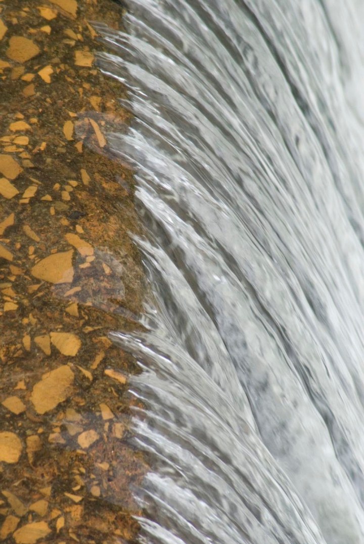water flowing over dam