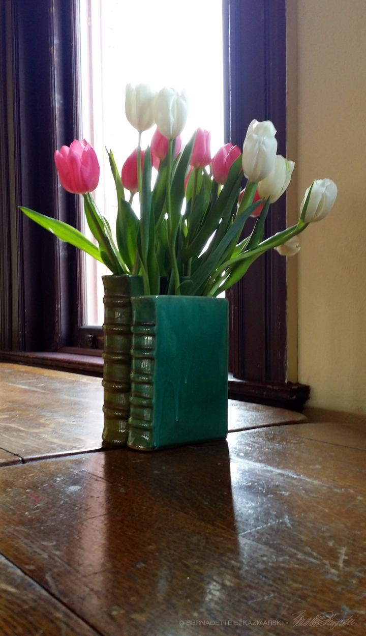 tulips in book vase on vintage table