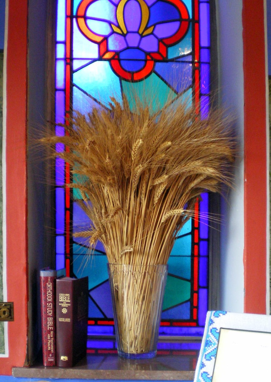 vase of wheat in front of stained glass window